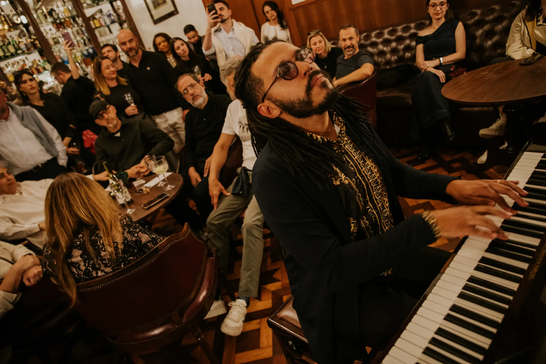 Pianista tocando com o público em volta, ouvindo de perto